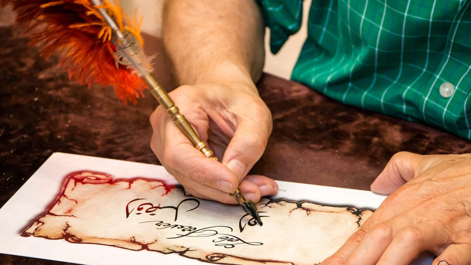 Een kalligraaf schrijft Arabische letters met een rietpen