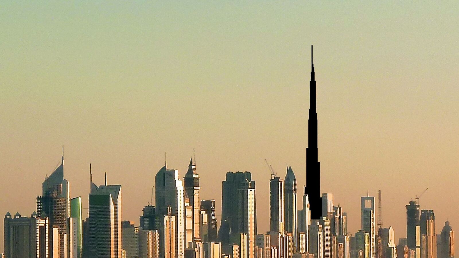 De skyline van Dubai met de Burj Khalifa bij zonsondergang